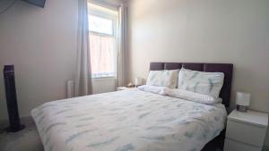 a bedroom with a large bed with a window at Modern holiday let in Skipton, North Yorkshire in Skipton