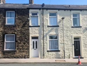 a brick house with a white door and windows at Modern holiday let in Skipton, North Yorkshire in Skipton