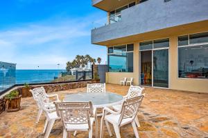 a patio with a table and chairs and the ocean at Casa Faraon Rosarito in Rosarito