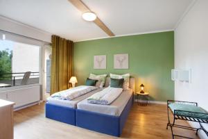 ein Schlafzimmer mit einem Bett und einer grünen Wand in der Unterkunft Kleine Auszeit in Brilon