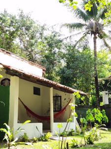 a house with a hammock on the side of it at Pousada Vila Gaia in Santo André