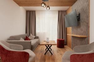 - un salon avec un canapé et une télévision dans l'établissement A CASA Amethyst, à Sölden
