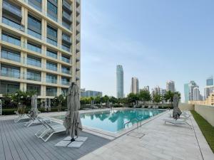 杜拜的住宿－Amazing apartment next to Dubai Mall 160BR-2，一座大楼内的游泳池,配有椅子和遮阳伞