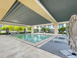 a swimming pool with awning and chairs in a building at Amazing apartment next to Dubai Mall 160BR-2 in Dubai