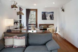 ein Wohnzimmer mit einem Sofa und einem Tisch in der Unterkunft HelloChalet - Ski paradise Apartment - Ski- to door with big terrace overlooking skiruns in Breuil-Cervinia