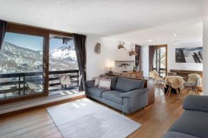 ein Wohnzimmer mit einem Sofa und einem großen Fenster in der Unterkunft HelloChalet - Ski paradise Apartment - Ski- to door with big terrace overlooking skiruns in Breuil-Cervinia