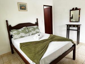 1 cama con 2 toallas en un dormitorio en Casa Perto do Centro, en Paraty