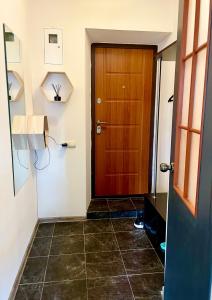 a hallway with a wooden door and a tile floor at Квартира Сапфір Avenue Myru 35a in Chernihiv