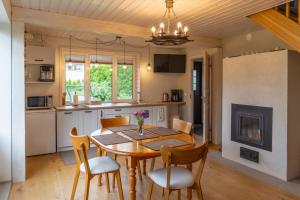 cocina y comedor con mesa de madera y sillas en Cosy Family Guesthouse with Sauna and Garden, en Kuressaare