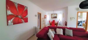 a living room with a red couch and a painting at Apartment in the center of Tavira with swimming pool and garage in Tavira