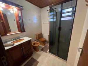 La salle de bains est pourvue d'une douche, d'un lavabo et de toilettes. dans l'établissement Apartamento Edelweiss 403, à Gramado
