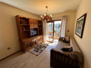 - un salon avec un canapé et un lustre dans l'établissement Apartamento Edelweiss 403, à Gramado