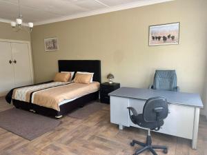 a bedroom with a bed and a desk and a chair at Beautiful Home in Houghton in Johannesburg