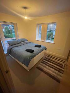 a bedroom with a large bed and two windows at April Disc - Long Stay - Contractors in Mangotsfield