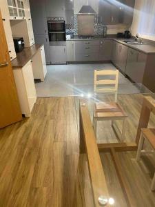 a large kitchen with a table and a chair in it at April Disc - Long Stay - Contractors in Mangotsfield