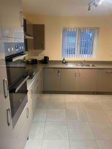 a kitchen with a sink and a stove top oven at April Disc - Long Stay - Contractors in Mangotsfield