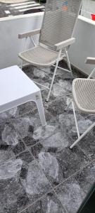 two chairs and a table on a tiled floor at Coral in Los Abrigos