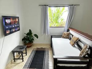 sala de estar con cama y ventana en Casa Perto do Centro en Parati