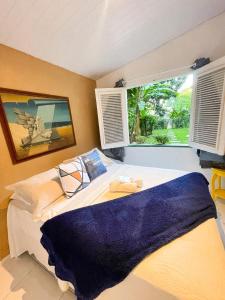 Un dormitorio con una cama grande y una ventana en Olho D'Água Pousada en Guaramiranga