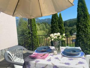 uma mesa com pratos e um vaso de flores em Casa de Vacanta Mountain View em Cheia