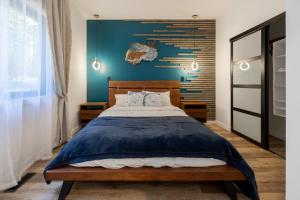 a bedroom with a large bed with a blue wall at New Modern Rustic A-Frame Cabin with Barrel Sauna in Nordegg