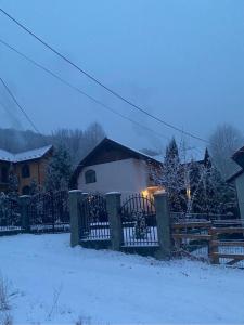 una casa con una valla en la nieve en Casa de Vacanta Mountain View, en Cheia