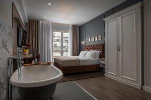 um quarto de hotel com uma banheira e uma cama em No 39 Svolou Suites em Tessalónica