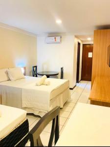 Habitación de hotel con 2 camas y mesa en Ponta negra Flat, en Natal