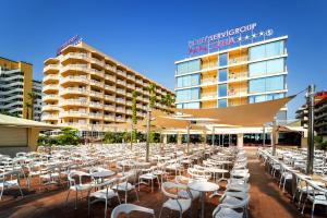 a row of tables and chairs in front of a hotel at Hotel Servigroup Papa Luna in Peniscola