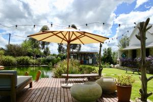 eine Terrasse mit einem Tisch und einem Sonnenschirm in der Unterkunft The tiny home in Riebeek-Wes + 3 Fotos