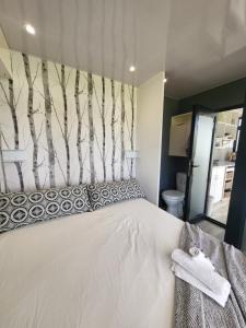 um quarto com uma cama com uma parede com árvores em The tiny home em Riebeek-Wes