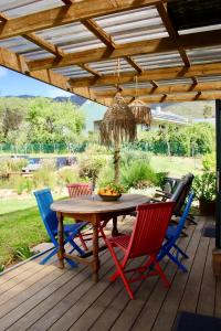 einen Holztisch und vier Stühle auf einer Terrasse in der Unterkunft The tiny home in Riebeek-Wes