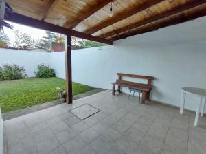 un patio con un banco de madera y una mesa en Los Ángeles Temporario en Córdoba