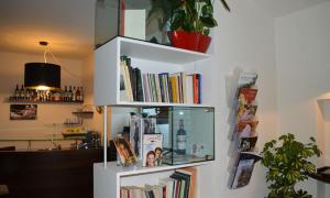 a white book shelf filled with books at Regalpetra Hotel in Racalmuto