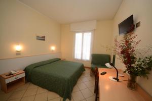 a hotel room with a green bed and a chair at Bike & Family Hotel Derby in Finale Ligure