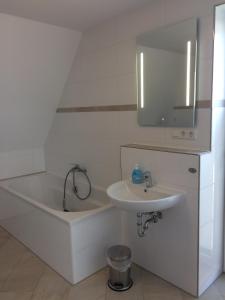 a bathroom with a bath tub and a sink at Ferienhaus Hillesheim in Hillesheim