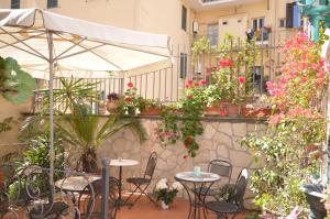 eine Außenterrasse mit Tischen, Stühlen und Blumen in der Unterkunft Hotel Alexis in Rom