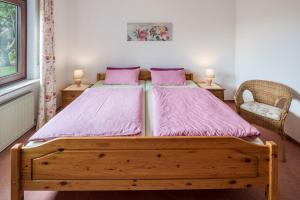 Schlafzimmer mit einem Holzbett mit rosa Bettwäsche in der Unterkunft Ferienwohnung Haus-schirmer in Bad Wildungen