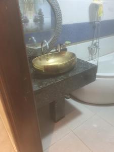 een badkamer met een gouden wastafel op een aanrecht naast een toilet bij شقه الخامس in Mansoura