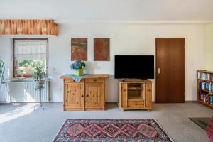 a living room with a flat screen tv and a wooden cabinet at Ferienwohnung Haus-schirmer in Bad Wildungen