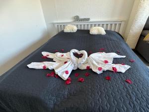 a bed with red hearts and white sheets on it at Südstrand Perle in Burgtiefe auf Fehmarn 
