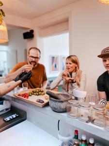 un gruppo di persone che si aggirano intorno a un bancone con cibo di Cordova Hostel Medellin a Medellín