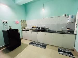 eine Küche mit einem schwarzen Kühlschrank und einer Spüle in der Unterkunft *URBAN HOME*-A Luxe Contemporary 1BHK Apartment in Guwahati