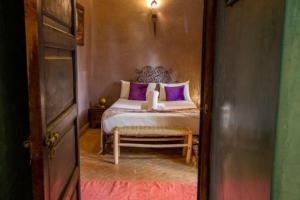 a bedroom with a bed with purple pillows at Riad en Exlusivité à 5min de la place jamaa el fna in Marrakesh