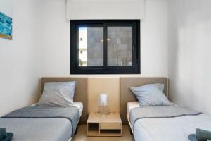 two twin beds in a room with a window at Flamenca Village Resort apt 83 in Orihuela +22 photos