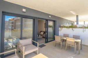 a patio with a table and chairs and a living room at Flamenca Village Resort apt 83 in Orihuela Costa