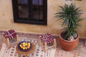 a table with two chairs and a bowl of fruit at Riad en Exlusivité à 5min de la place jamaa el fna in Marrakesh