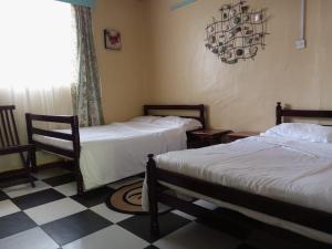 una camera con due letti e un pavimento a scacchi di Quiet Place a Kikuyu