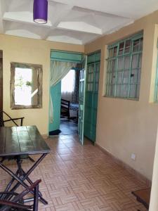 een lege kamer met een tafel en stoelen en een deur bij Quiet Place in Kikuyu