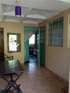 una stanza vuota con tavolo e porte in vetro verde di Quiet Place a Kikuyu